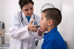 Respiratory Therapist gives inhaler to young boy