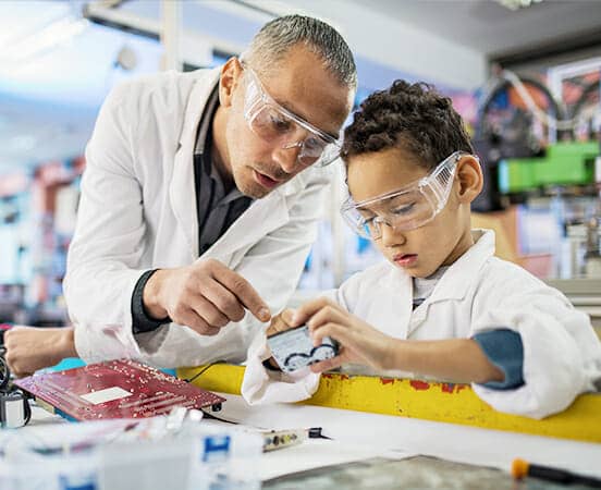 Man teaching child in labcoats