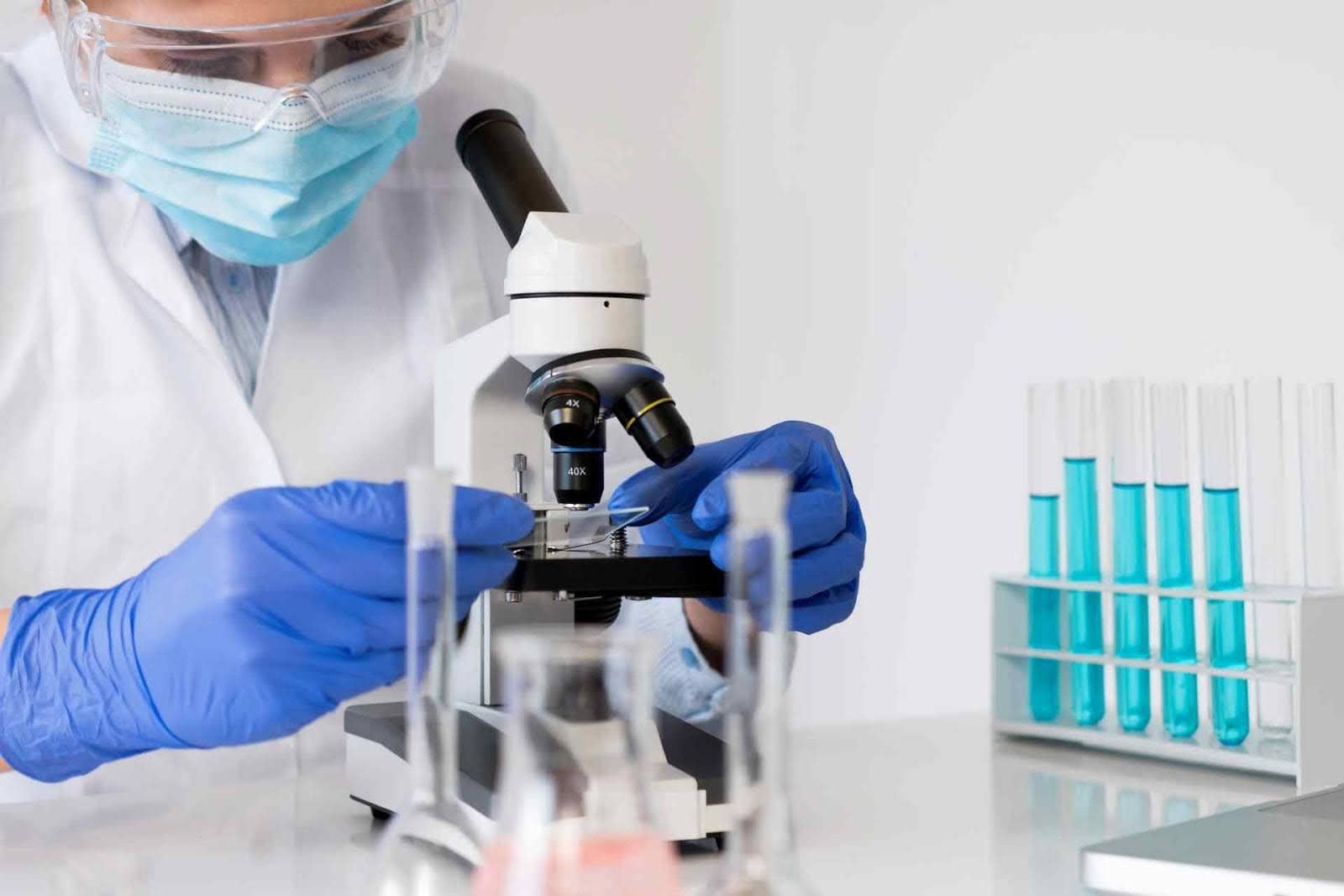 Laboratory scientist reviewing samples under a microscope